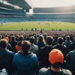 Génération Z et sport : comment les créateurs de contenu redessinent la passion sportive Jeunes spectateurs dans des tribunes regardant du contenu sportif sur smartphone